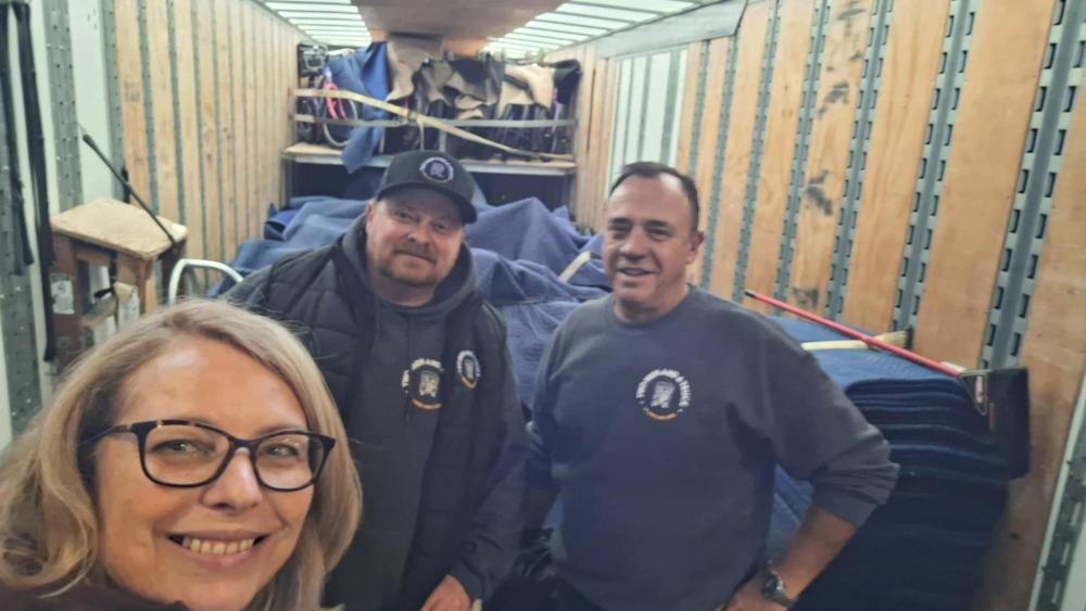 3 people taking a picture in the back of a truck
