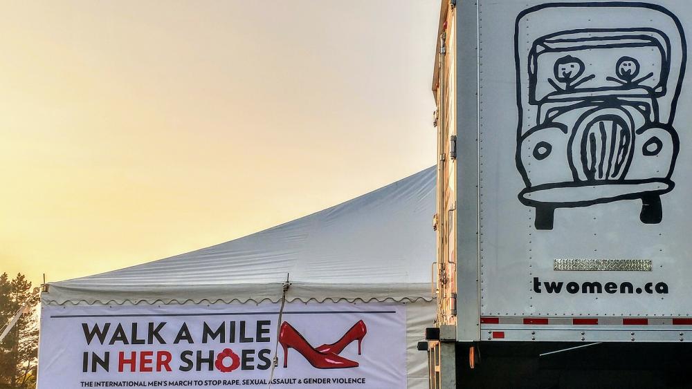 Two Men and a Truck, truck in front of a tent for the Women's & Children Shelter 