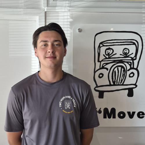 Mover standing in front of a Two Men and a Truck sign