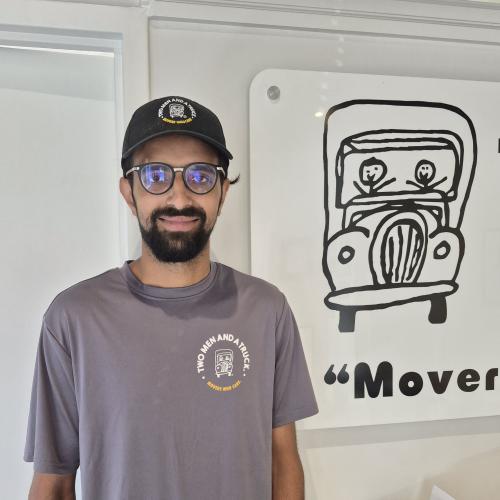 Mover standing in front of a Two Men and a Truck sign